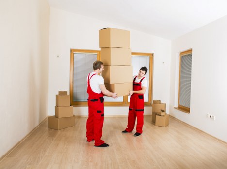 Movers handling boxes and furniture in a managed apartment building