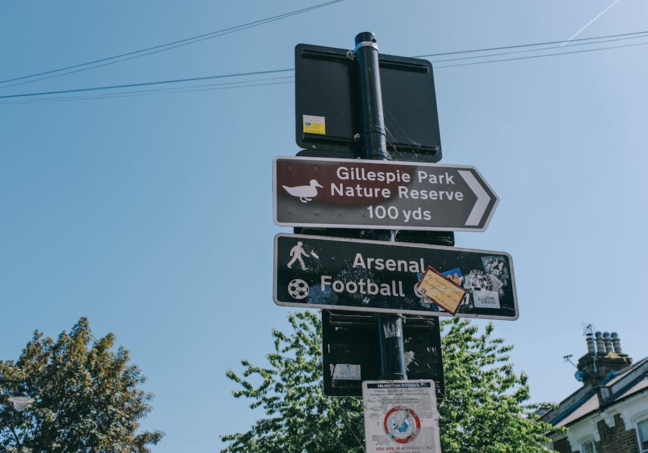 A rectangular road sign mounted on a black pole against a clear blue sky, with bold black text reading 'City Centre' and an upward-pointing arrow symbol indicating the direction. The sign is located outdoors, likely on a street or near a transport route, providing directional guidance. The image is relevant to house removals and packing and moving services offered by Man with Van Isle of Dogs, especially when navigating urban areas such as Westferry Road in E14, Isle of Dogs, during a home relocation or furniture transport process.